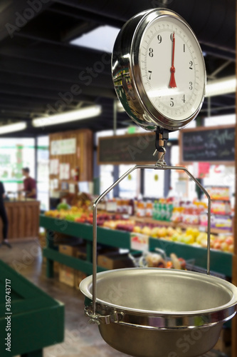 Produce scale in supermarket with people in background