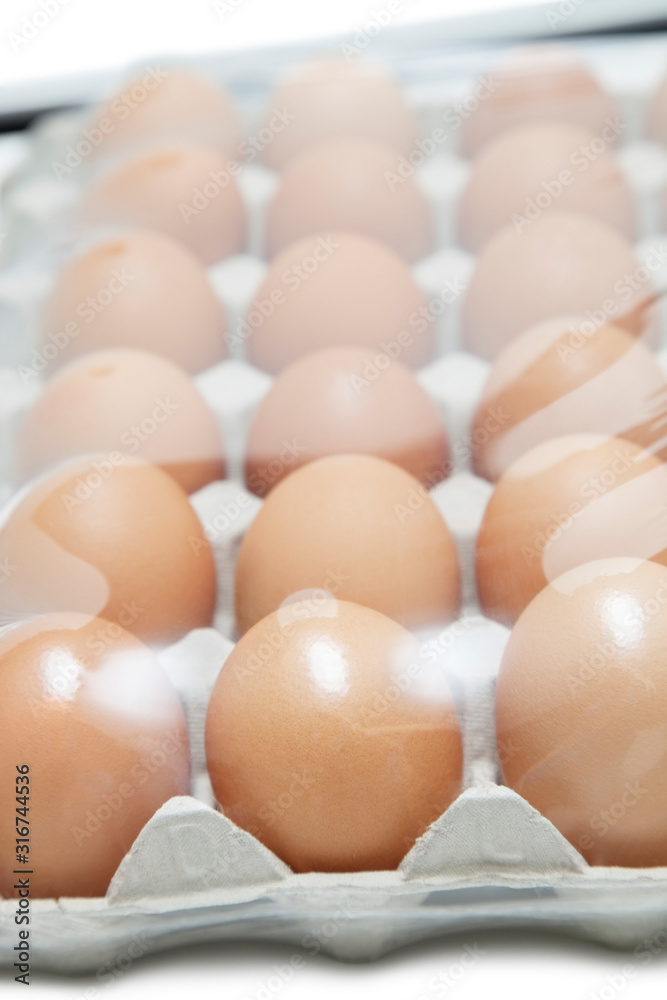 Brown eggs arranged in carton with plastic covering it Brown eggs arranged in carton with plastic covering it