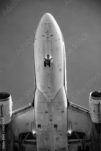 Black and white close-up shot of the belly of an Airbus A320 landing taken from underneath the aircraft photo