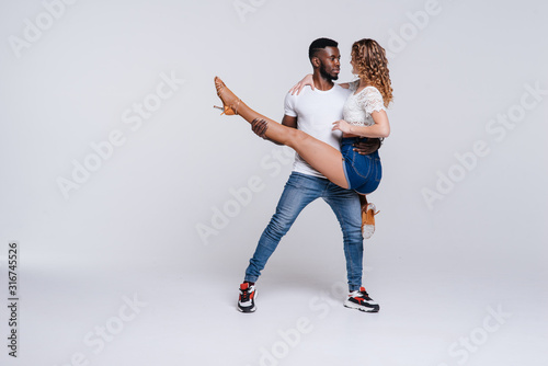 Couple dancers posing over white background. Man and woman are dancing, dance costumes. International dance group. Dancers dance. Passionate original variety of pair of dancers. Fitness concept