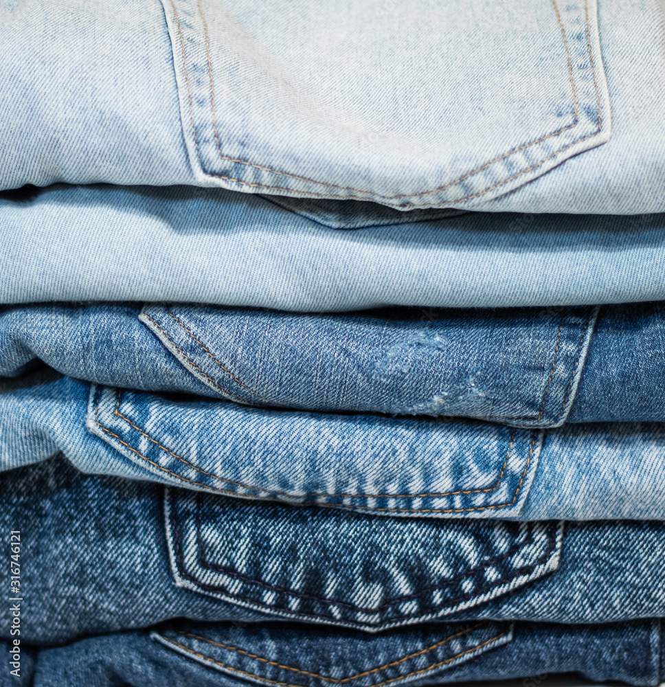 A pile of folded jeans in blue Background of clothing in indigo A pile of folded jeans in blue Background of clothing in indigo