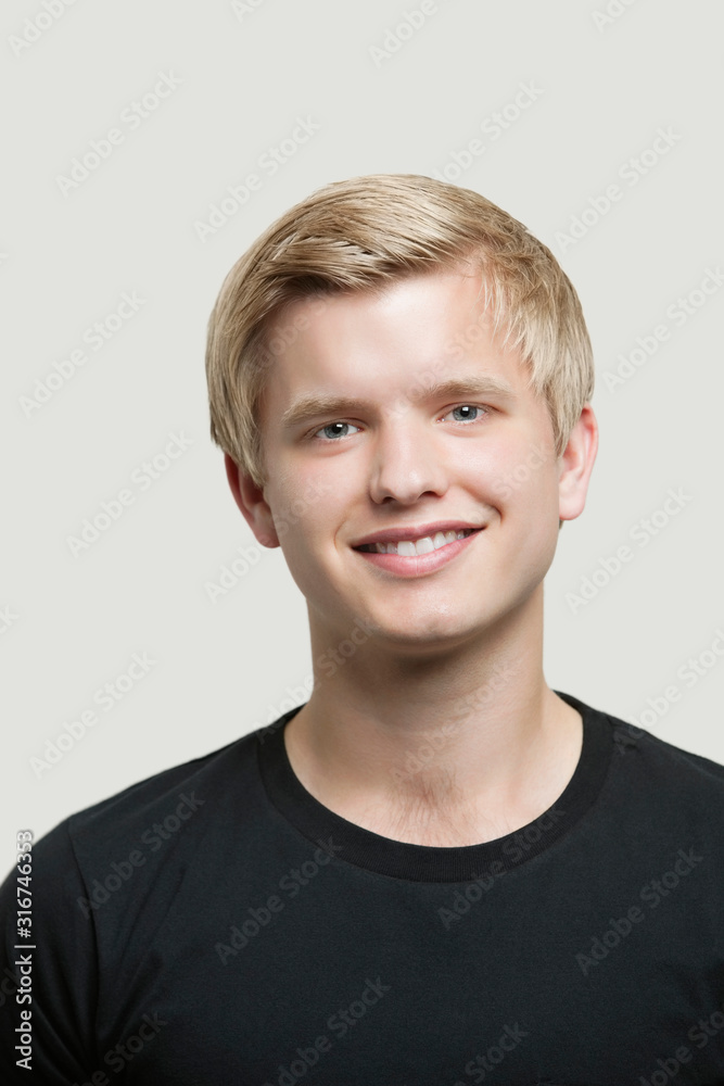 Portrait of happy young man against gray background Portrait of happy young man against gray background