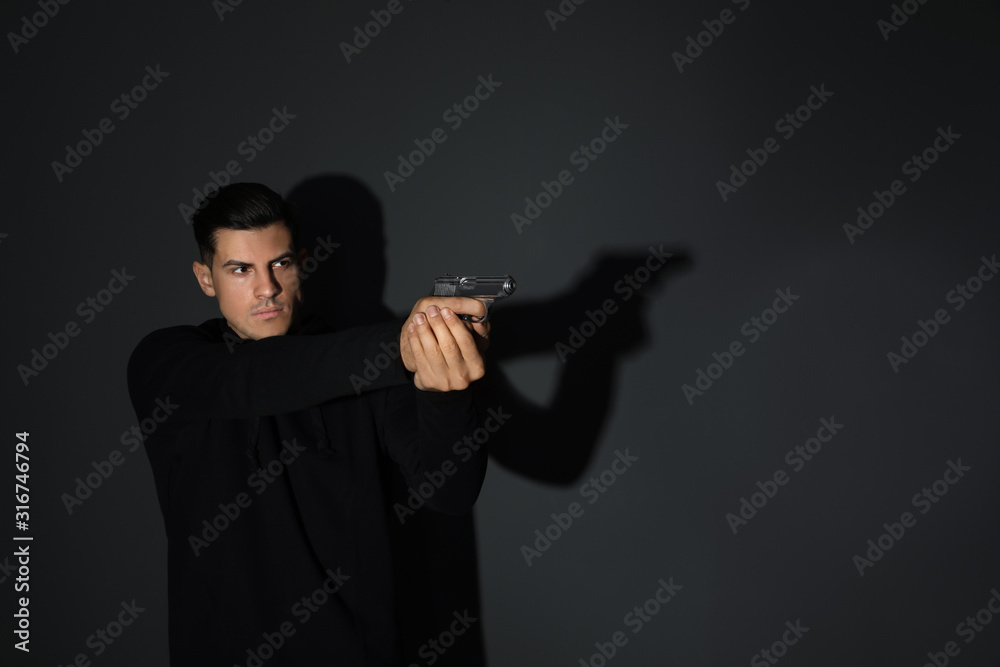Professional killer with gun on black background Professional killer with gun on black background
