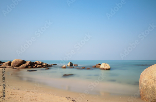 Beautiful Tranquil Long Exposure of the rock on the beach © Pattana