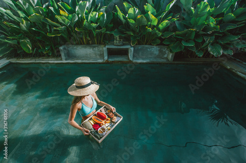 Girl relaxing and eating fruits in the pool on luxury villa in Bali © Alena Ozerova
