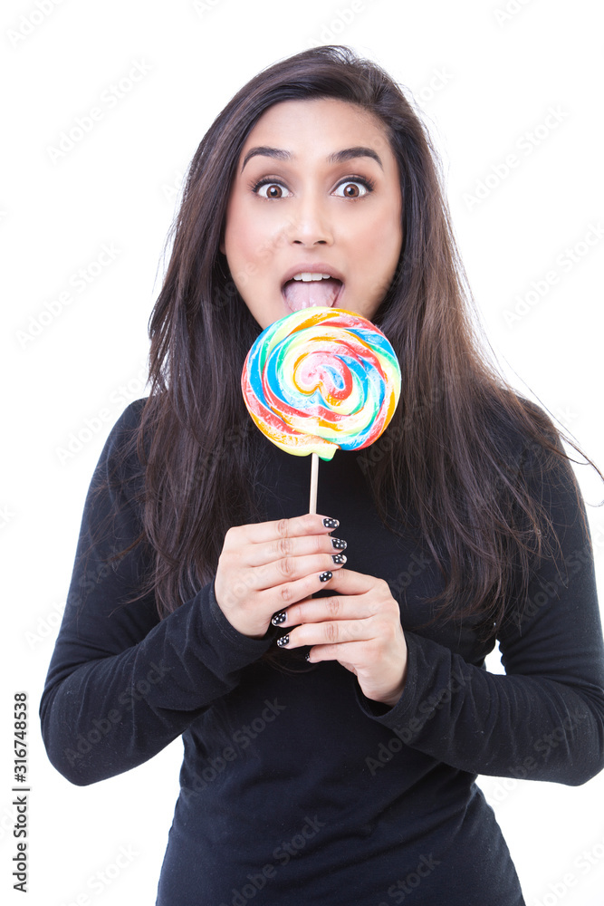 Portrait of young attractive woman licking lollipop