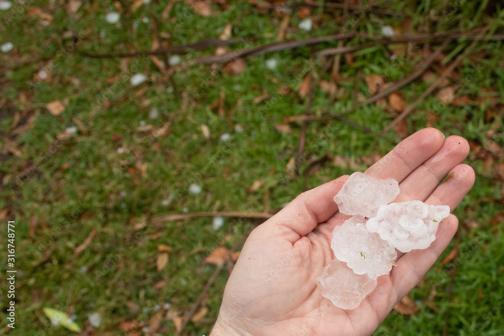 Hands holding large hailstones after severe hailstorm in Sydney, Australia Hands holding large hailstones after severe hailstorm in Sydney, Australia