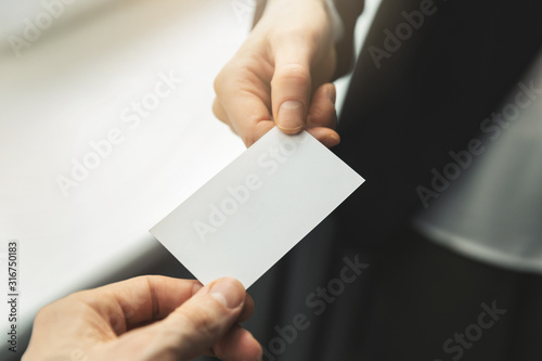 close up of people swapping blank business card. mockup