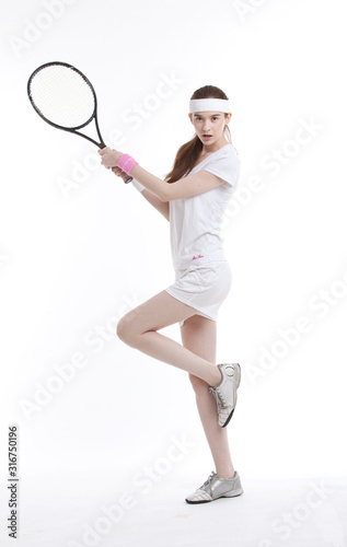 Portrait of young attractive woman hitting the ball with tennis racket © moodboard
