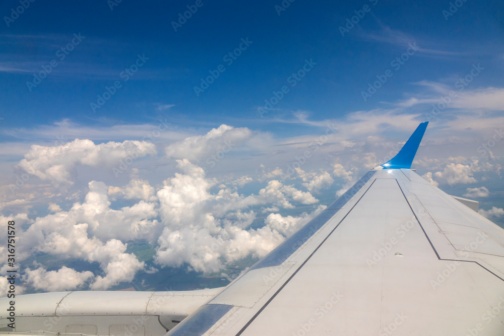 Wing of the plane on blue sky cloudy background. Wing of the plane on blue sky cloudy background.