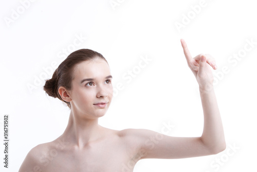 Shirtless beautiful young woman pointing up against white background