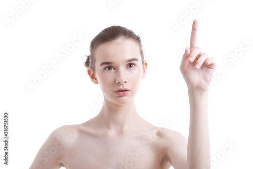 Shirtless beautiful young woman pointing up against white background