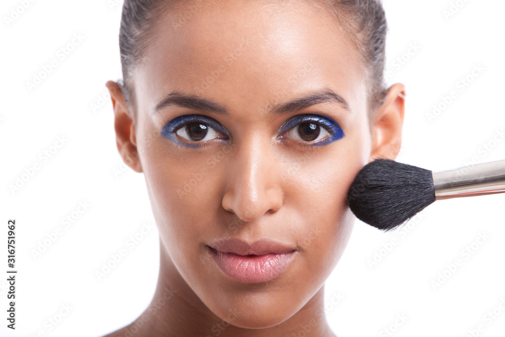Portrait of beautiful young woman applying makeup against white background Portrait of beautiful young woman applying makeup against white background