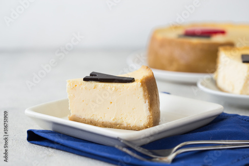 Delicious slice of new york cheesecake with word on white background. Sweet and tasty food, coffee break concept. Classic american dessert.