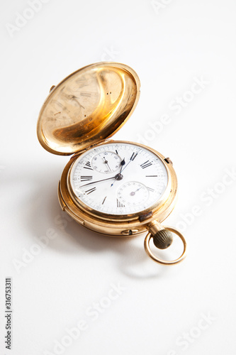 Golden pocket stopwatch over white background