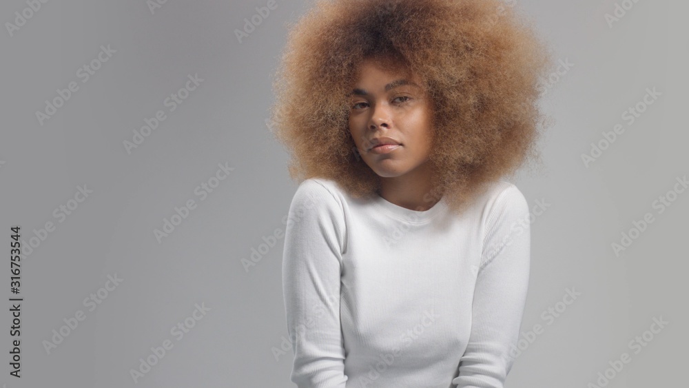 Mixed race black woman with big afro hair in studio watching t the camera. z generation, young model without makeup, beauty diversity Mixed race black woman with big afro hair in studio watching t the camera. z generation, young model without makeup, beauty diversity