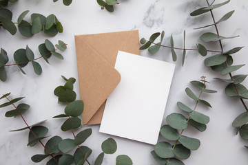 Blank white card and envelope with eucalyptus leaves. Blank invitation.