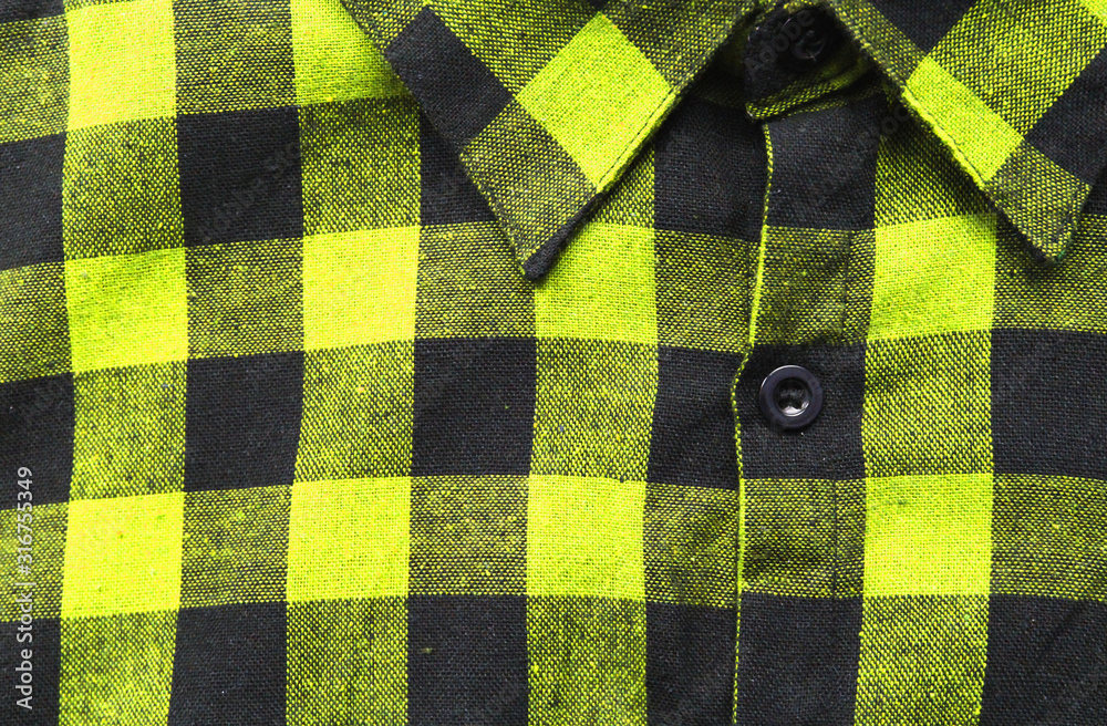 Checkered flannel shirt close up, bright vivid yellow and black tartan  pattern clothes. Detail of trendy colorful yellow lumberjack women's shirt,  plaid cotton square top for men and women Stock Photo