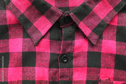 Pink colorful plaid flannel shirt with tartan pattern. Vivid pink or light purple shirt, close up top view of stylish clothing for men and women 