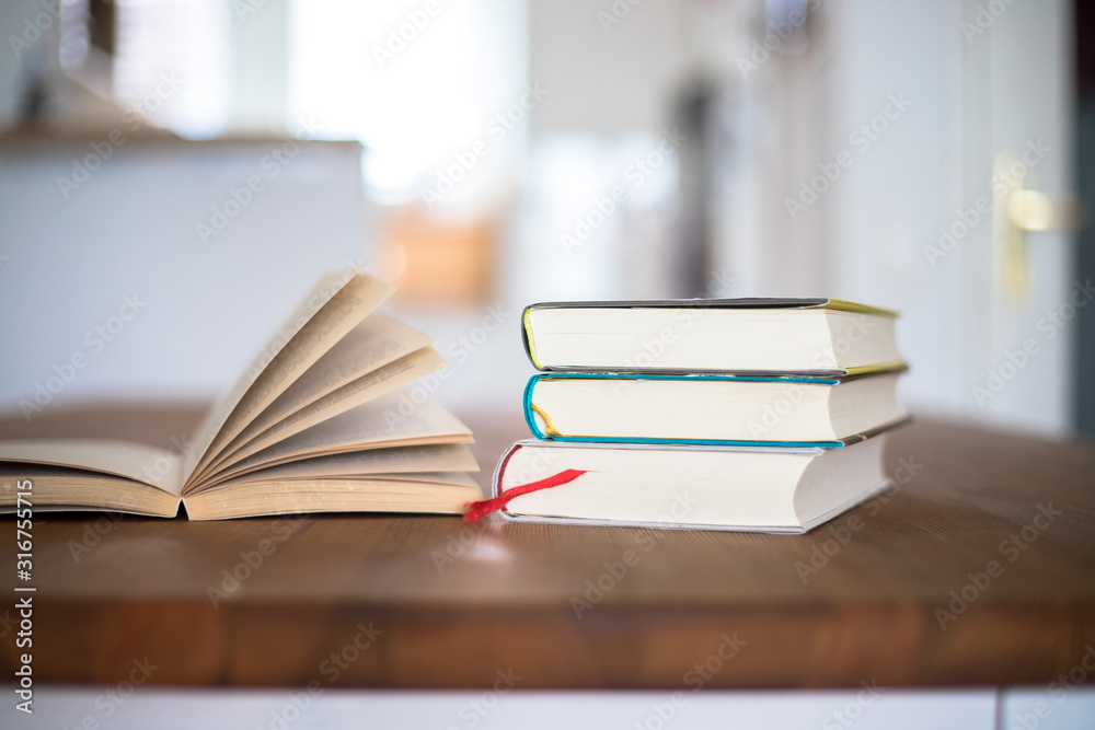 Fototapeta premium Knowledge and science concept: Stack of books lying on wooden desk, home.