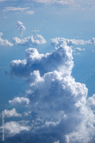 Vertical background of big clouds in a blue clear sky.