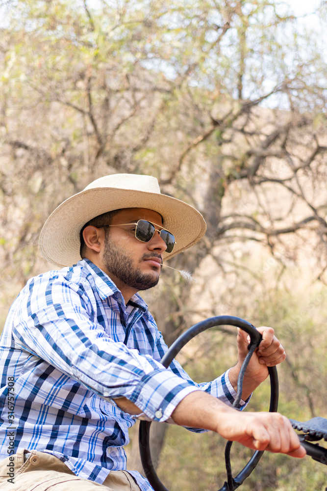 Attractive young man with sunglasses on a red tractor