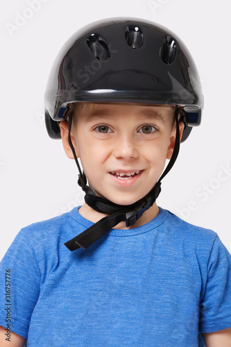 Portrait of a happy little boy wearing bicycle helmet over white background