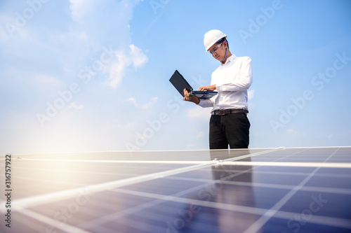 Solar power plant. Engineer & Manager with tablet computer on photovoltaic panels, on building roof ,  Renewable energy Concept