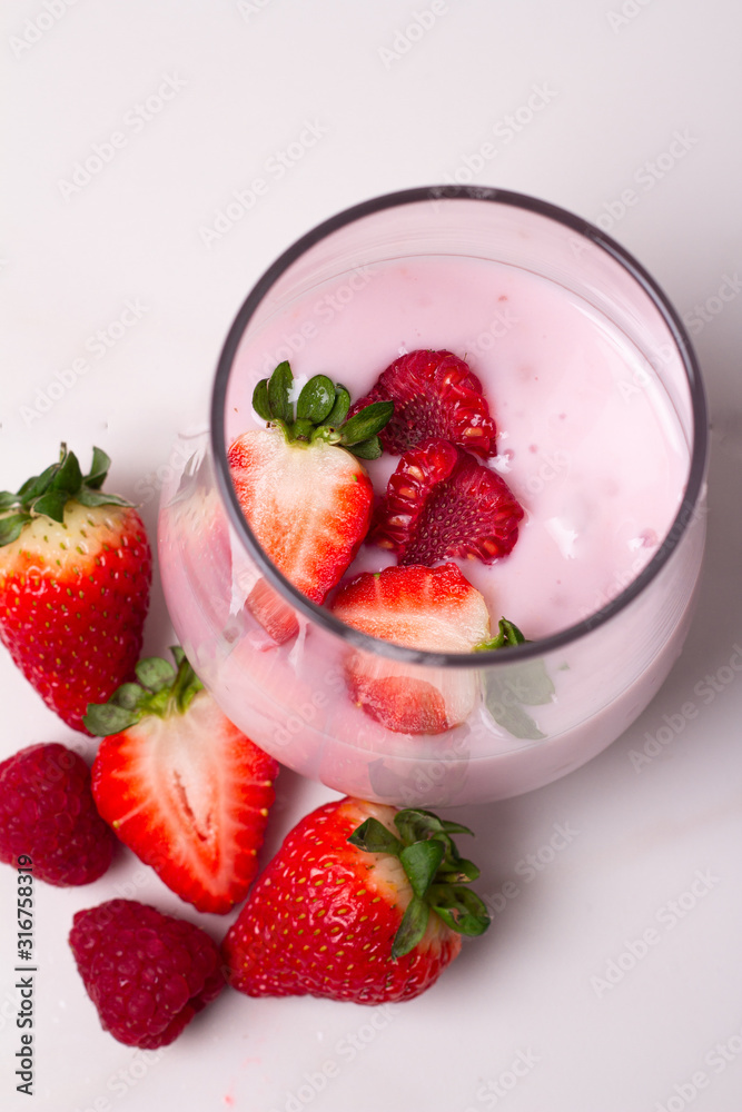 glass with yogurt and fresh berries on a white background top view glass with yogurt and fresh berries on a white background top view