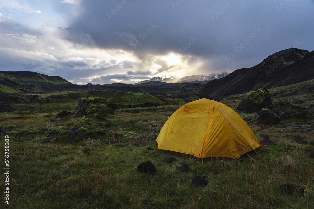 Yellow camping tent in an open moss field during sunset. Shot on adventure in Icelandic highlands