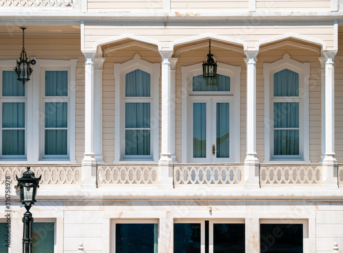 Wooden mansion close up detail. Beautiful classic architecture balcony with arch columns and many windows.