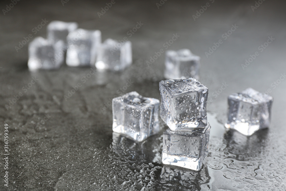 Crystal clear ice cubes on grey stone table. Space for text Crystal clear ice cubes on grey stone table. Space for text