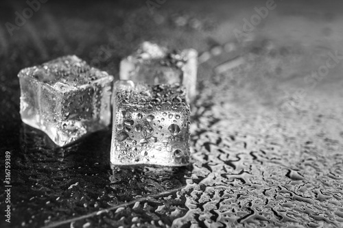 Fototapeta Naklejka Na Ścianę i Meble -  Crystal clear ice cubes on grey stone table, closeup. Space for text