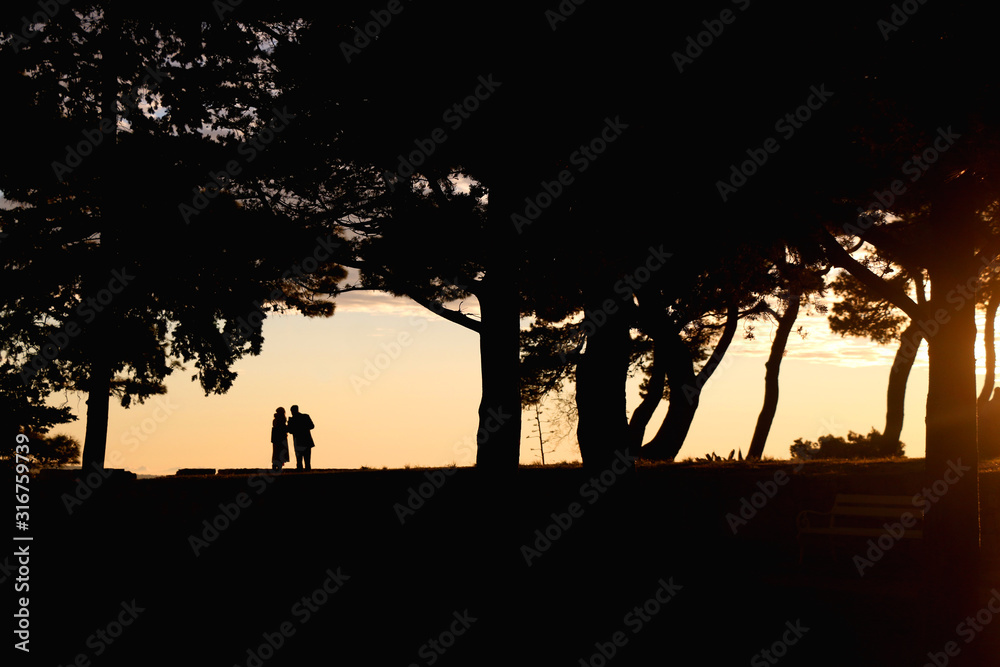 Silhouettes of unrecognizable people enjoying the sunset in Sustipan park in Split, Croatia. Silhouettes of unrecognizable people enjoying the sunset in Sustipan park in Split, Croatia.