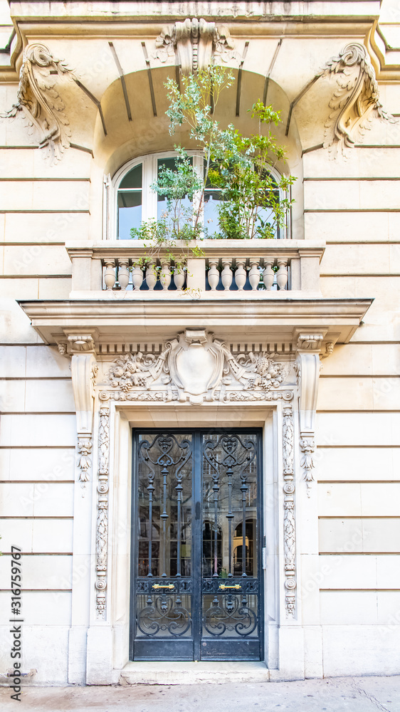 Obraz premium Paris, a wooden door, typical building in the Marais, with a beautiful stone balcony