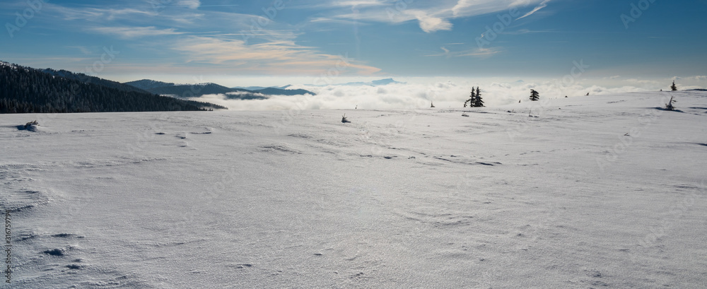 snow covered mountain meadow with hills on the background and blue sky with clouds snow covered mountain meadow with hills on the background and blue sky with clouds