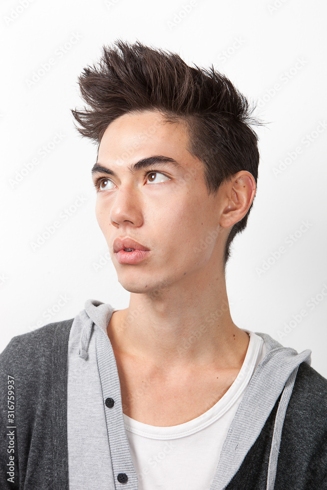 Thoughtful young mixed race man looking away against white background Thoughtful young mixed race man looking away against white background
