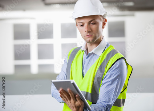 Young Caucasian architect using digital tablet at office