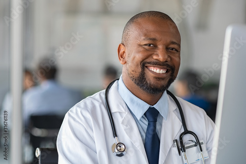 Obraz na plátne Happy smiling black doctor looking at camera