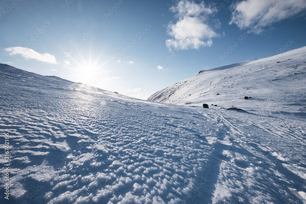 Snowy hill with sunlight and blue sky on winter at Lofoten Islands