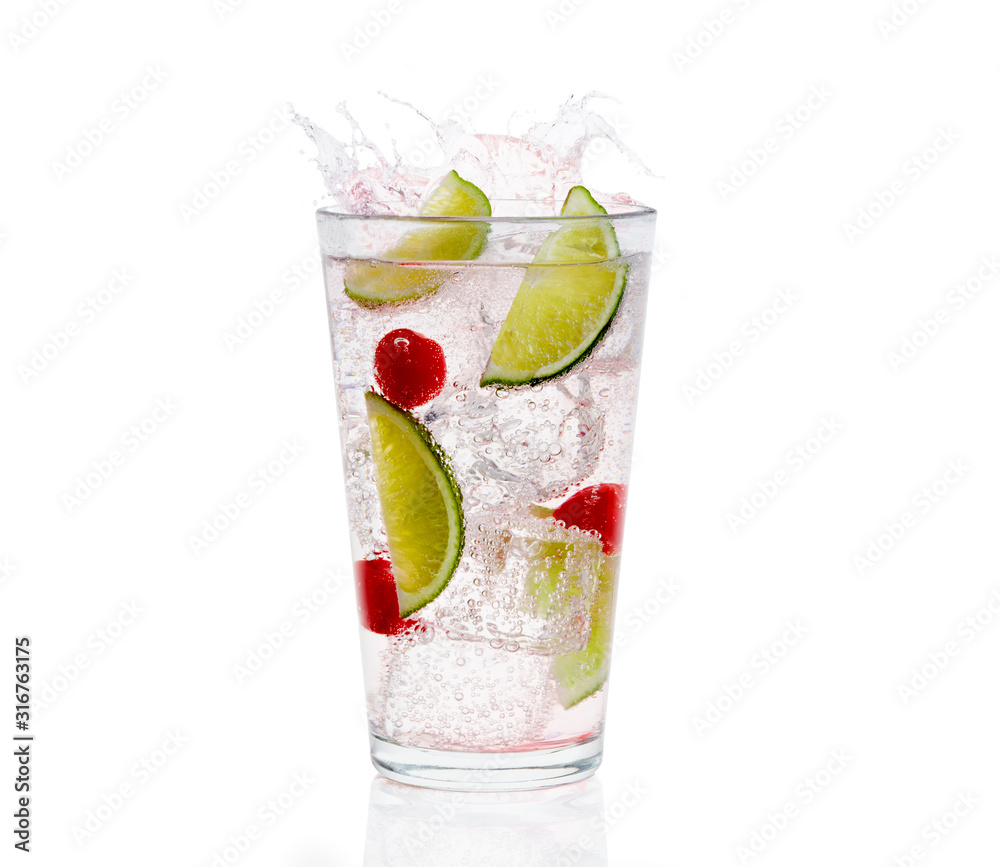 Clear glass of carbonized clear liquid with ice cubes, cherries, and lime wedges in the glass Clear glass of carbonized clear liquid with ice cubes, cherries, and lime wedges in the glass