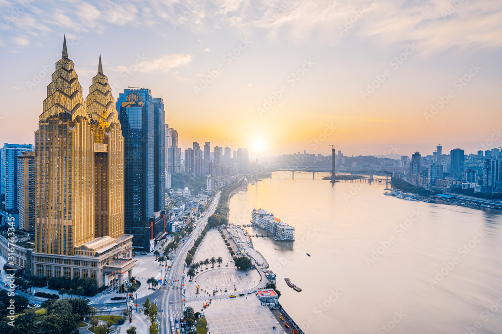 Obraz premium Dusk view of golden high-rise buildings along the Yangtze River in Chongqing, China