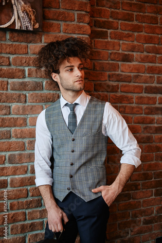 Attractive bearded young man in classic vest and tie. Elegancy a