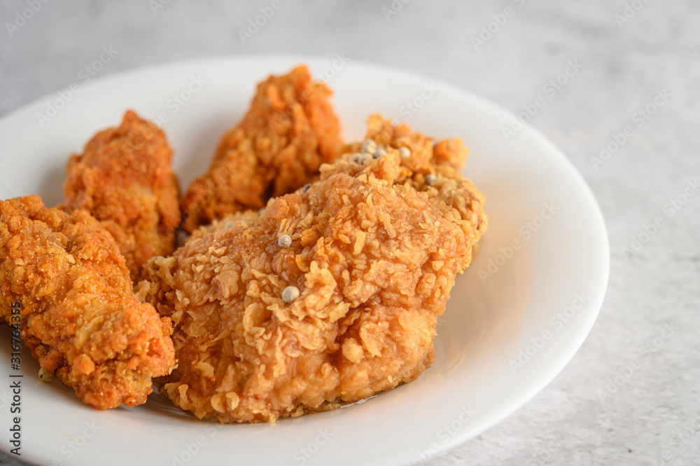 Crispy fried chicken sprinkled with pepper seeds on a white plate, Selective focus. Crispy fried chicken sprinkled with pepper seeds on a white plate, Selective focus.