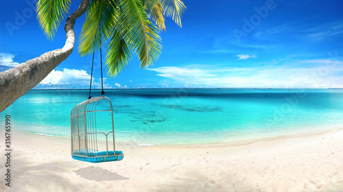 Fototapeta Naklejka Na Ścianę i Meble -  Beautiful tropical beach with white sand, turquoise ocean on  background blue sky with clouds on sunny summer day. Tilted palm tree with swing. Perfect landscape  background for relaxing vacation.