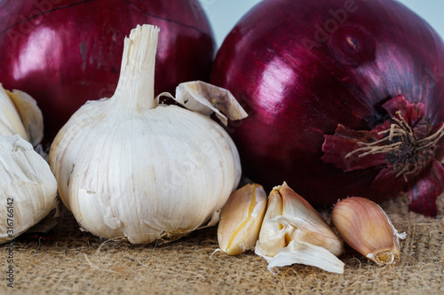 Selective focus.  Fresh onion and garlic over brown background.