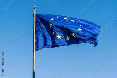 Flag of European Union (EU) against blue sky.