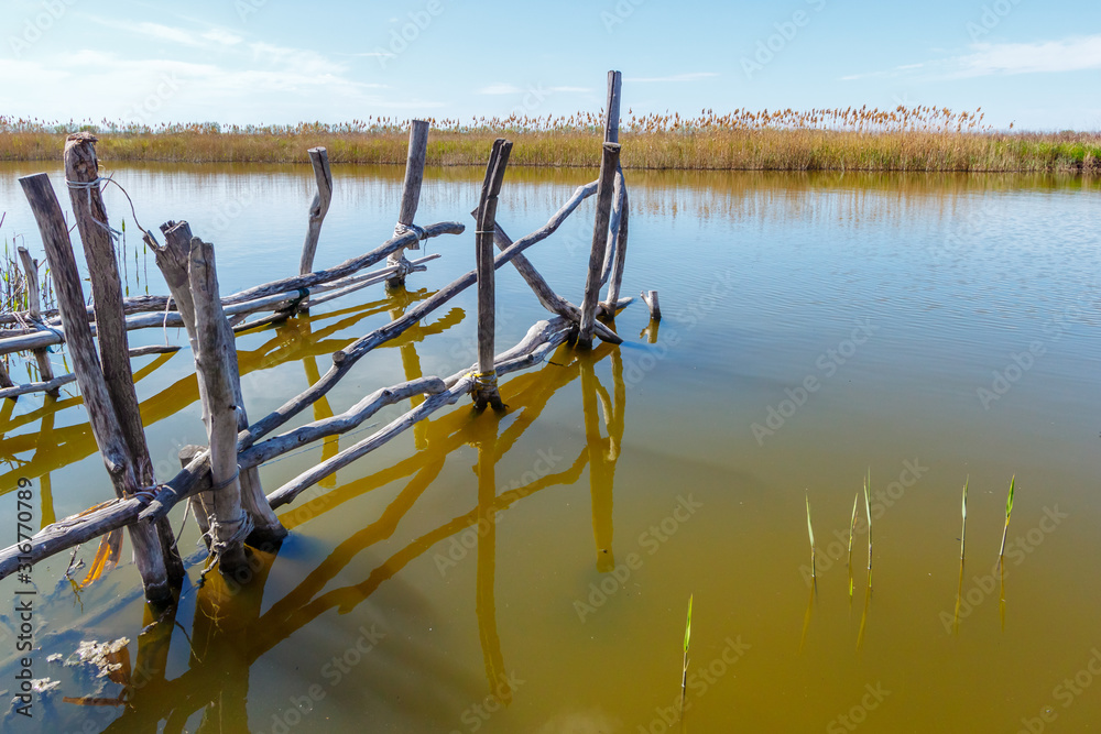 The remains of an old abandoned wooden fishing platform in river water  Stock Photo