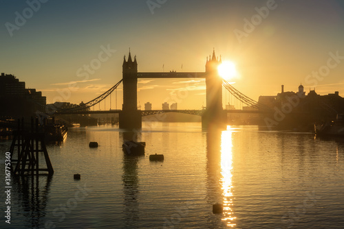 Silhouette of Tower Bridge reflects in Thames river during sunrise  London  UK