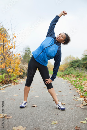 Young woman stretching in park